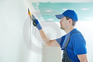 Refurbishment. Worker spackling a wall with putty