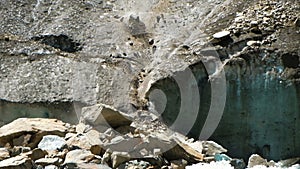Slow motion rockfall in the mountains close up. Lumps of stones fall down from the melting glacier