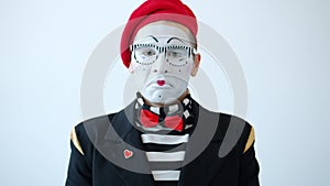 Slow motion of sad mime artist looking at camera with unhappy face on white background