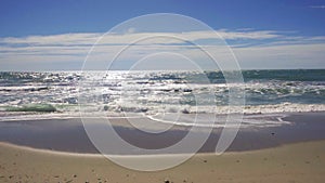 Slow motion sea waves breaking on a sandy beach in Costa dorada, Spain.
