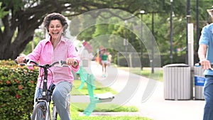 Slow Motion Sequence Of Senior Couple Riding Bikes In Park