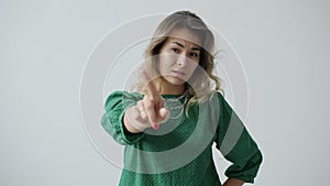 Slow motion of serious young woman wagging finger warning expressing disagreement on white background