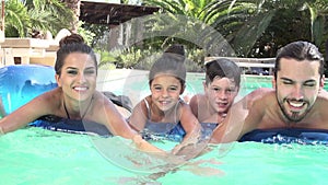 Slow Motion Shot Of Family On Airbed In Swimming Pool