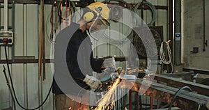 Slow motion shot of a worker grinding metal using a metal grinder