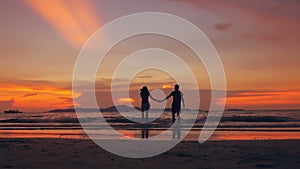 Slow motion silhouette of happy loving couple kiss and go to beach on sunset in ocean shore