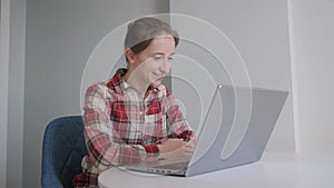 Slow motion: smiling woman using laptop, having video chat with friends at home