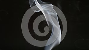 SLOW MOTION: Smoke steam into cigarette smoke on a black background