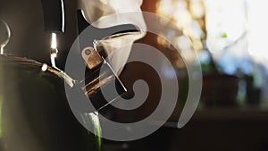 Slow motion: steaming tea kettle in the morning, close up