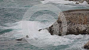 Slow motion stormy Mediterranean sea waves crushing over rocks