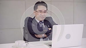 Slow motion - Successful Asian CEO businessman wearing suit working with laptop at work desk at office workplace.