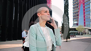 Slow motion. Successful business woman with suit alking and talking by mobile phone. Businesswoman having a call