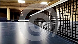 Slow motion table tennis table and table tennis net in close-up view with net mesh details