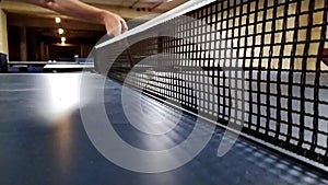 Slow motion table tennis table and table tennis net in close-up view with net mesh details