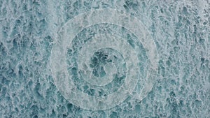 Slow-motion top down aerial view of the ocean giant waves, foaming and splashing