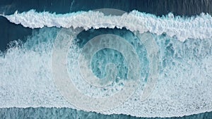 Slow-motion top down aerial view of the ocean giant waves, foaming and splashing