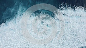 Slow-motion top down aerial view of the ocean giant waves, foaming and splashing