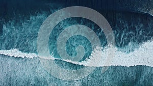 Slow-motion top down aerial view of the ocean giant waves, foaming and splashing