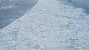 Slow-motion top down aerial view of the ocean giant waves, foaming and splashing