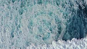 Slow-motion top down aerial view of the ocean giant waves, foaming and splashing