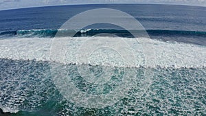 Slow motion top down aerial view of the ocean giant waves, foaming and splashing