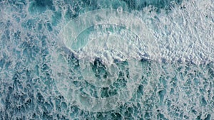 Slow motion top down aerial view of the ocean giant waves, foaming and splashing