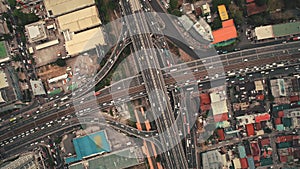 Slow motion top down of cross road traffic: cars, trucks, vehicles in aerial. Manila city downtown