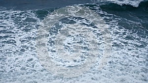 Slow motion Top view. Sea surf during a storm. Huge storm waves roll onto the shore covered with white foam. Boundless