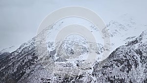 Slow motion. Top view of the snow-capped mountain slopes and the valley..