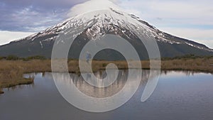 Slow motion - traveler wlking cross view to the taranaki volcano in the north island of new zealand and with the