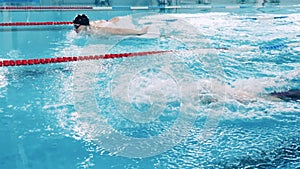 Slow motion of two butterfly swimmers crossing the pool