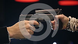 SLOW MOTION: Two male hands with guns take aim at each other