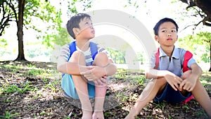 Slow motion of two young Asian boy sit in a park