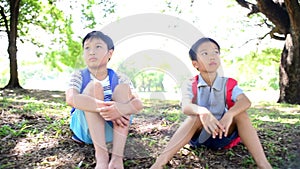 SLow motion of Two young asian boy sit in a park