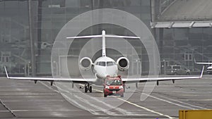 Slow-motion video as an escort car at the airport leads a private small plane