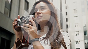 Slow motion video of beautiful brunette girl holding vinatge manual camera