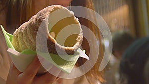 Slow motion video of girl holding trdelnik, Czech national sweet dish, tourism