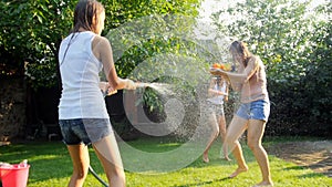Slow motion video of happy family splashing water on each other at backyard garden