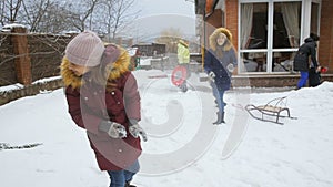 Slow motion video of two sisters having snow ball fight at backyard