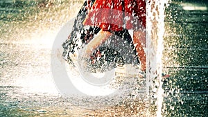 Slow motion video of two young women walking in park fountain on a hot summer day