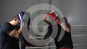 Slow motion view of sportsmen fighting at boxing ring