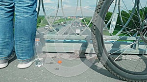 Slow motion view of traffic on Moscow ring highway. Frog eye view of bike wheel and man`s legs on bridge over MKAD.