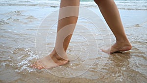 Slow motion woman feet walking on the sand beach with nature sea wave coast for summer vacation concept