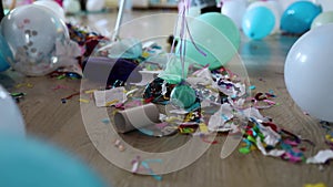 Slow motion, Woman with pushbroom cleaning mess of floor in room after party