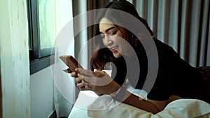 Slow-motion of woman using smartphone on bed