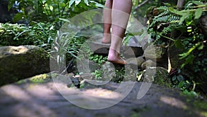 Slow motion of women walking in the garden. Lonely girl feet without shoes in the forest.