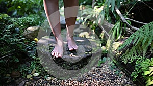 Slow motion of women walking in the garden. Lonely girl feet without shoes in the forest.