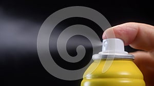 Slow motion of yellow spray bottle drops on black background