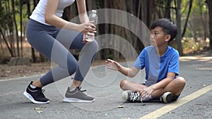 Slow motion Young Asian boy get a bottle of water from his sister