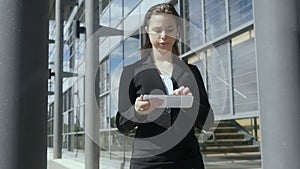 Slow motion young businesswoman walking working tablet pc outside Slow motion