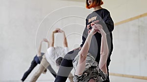 Slow motion young group people in yoga class practicing yoga and doing stretching exercises for legs and back.